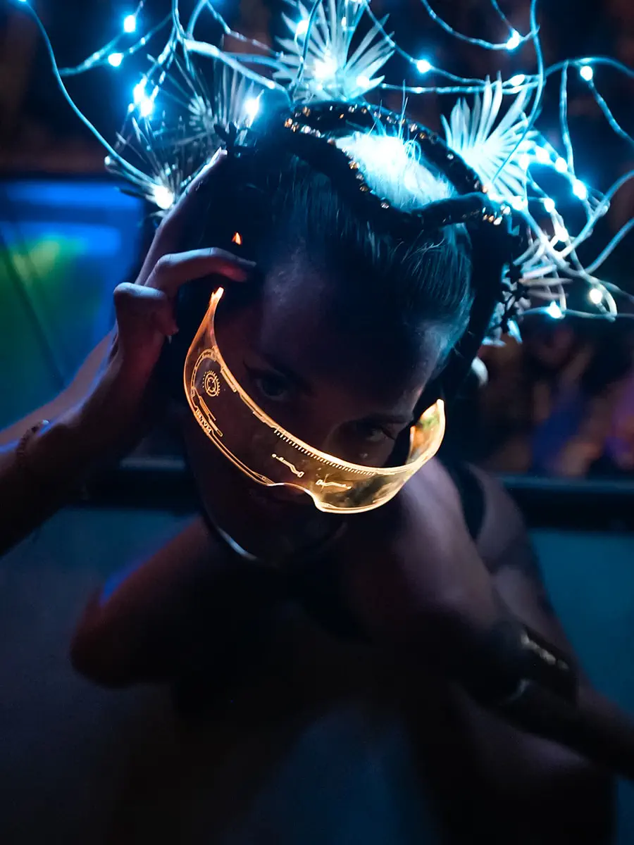 Portrait of a performer wearing a gold mask and an LED light headpiece