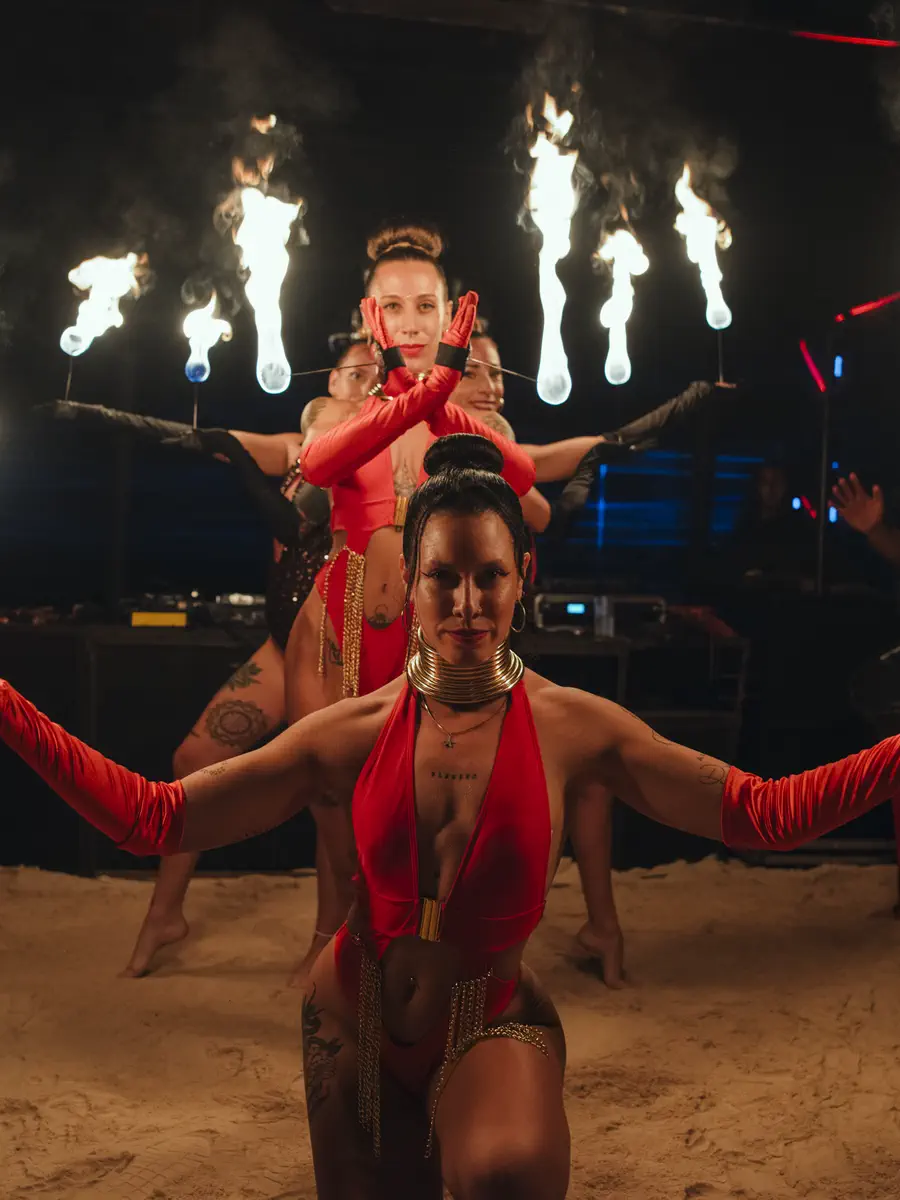 Four fire artists in formation on the beach at night